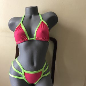 Neon Vibes hot pink and green two-piece bikini on mannequin, featuring strappy sides and silver ring accents