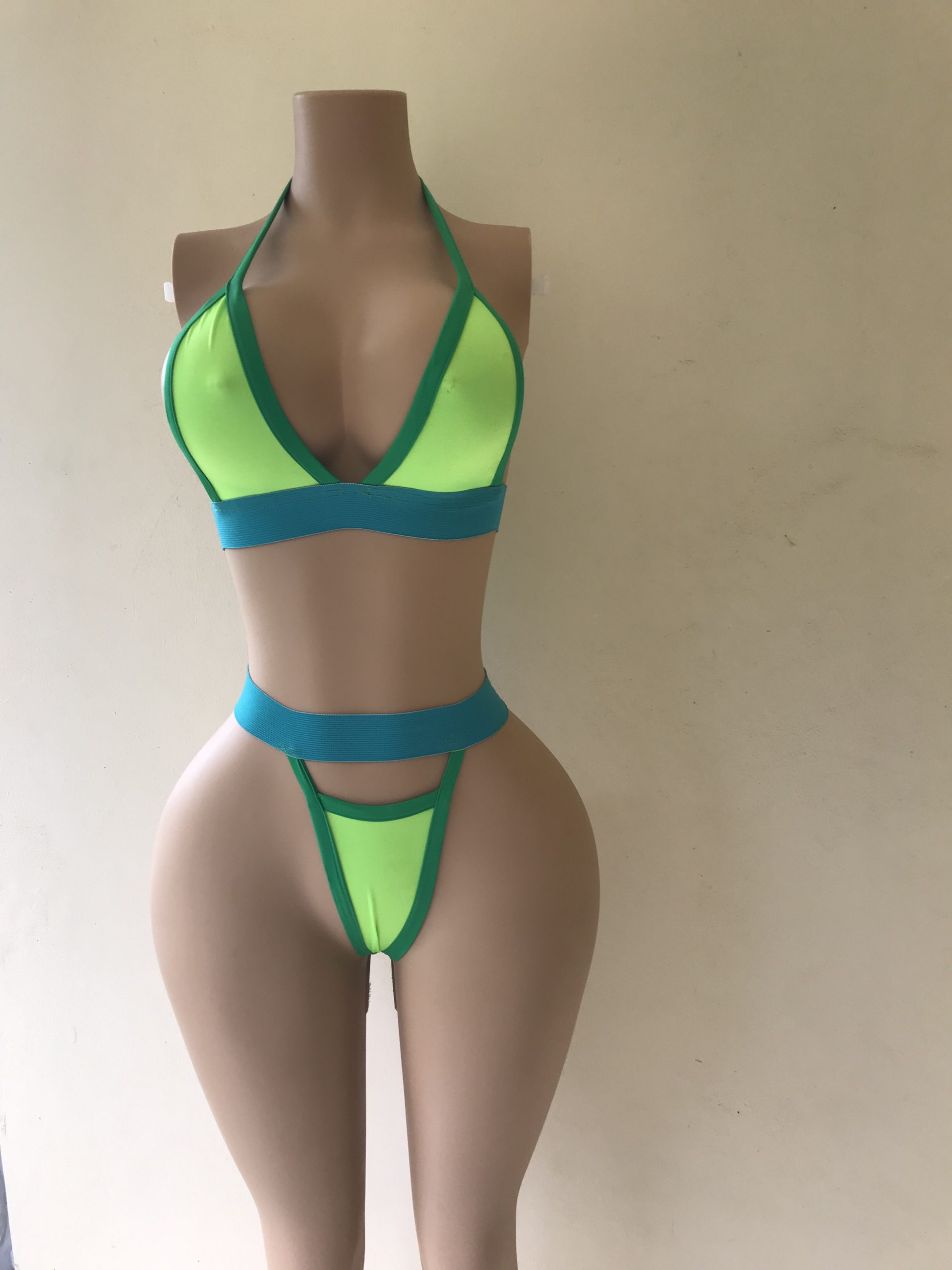 Voltage bikini in neon green with turquoise trim and high-cut thong design – front view on mannequin