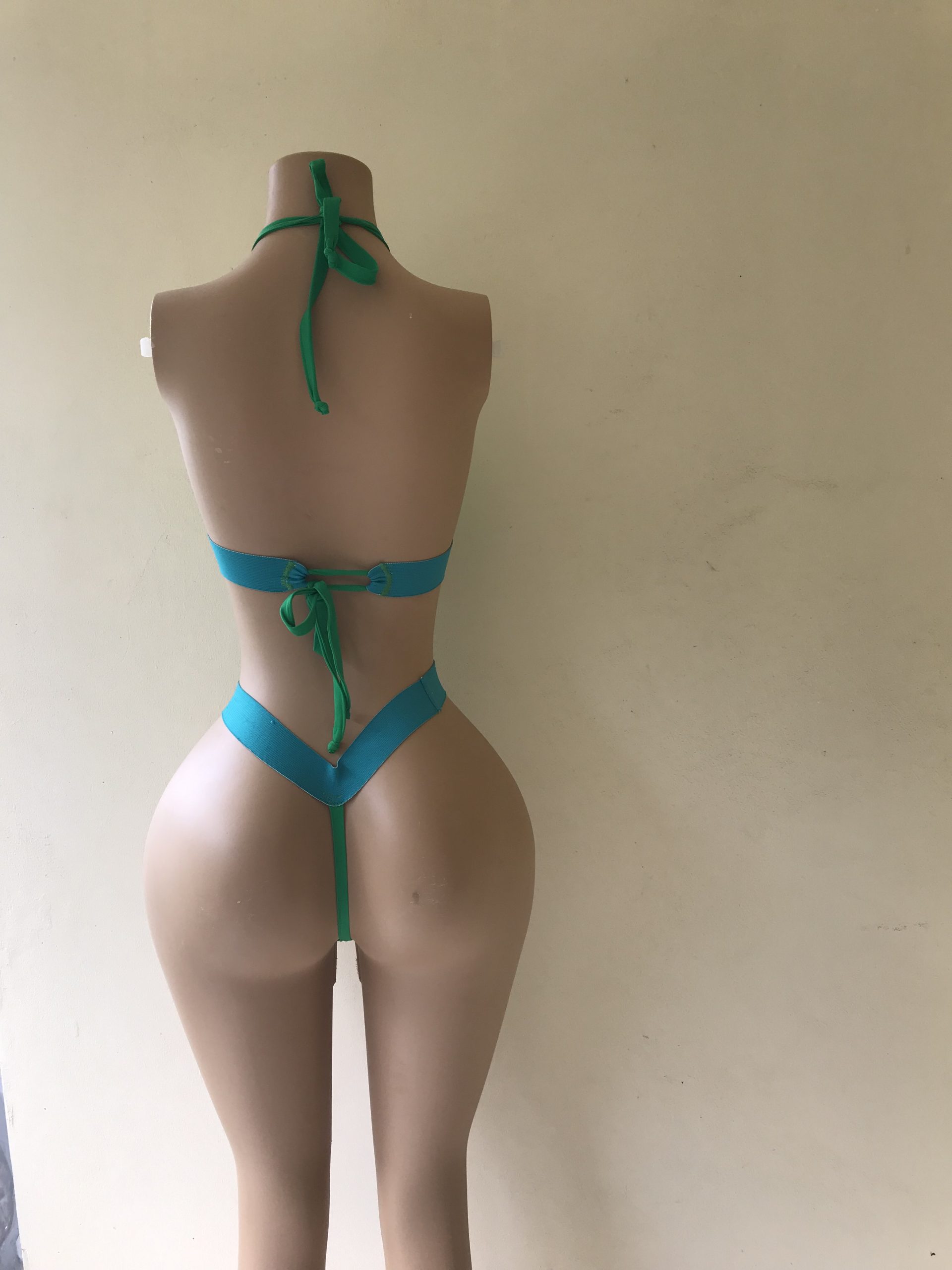 Lightning bikini in white with neon green trim and thong back with turquoise waistband – back view on mannequin