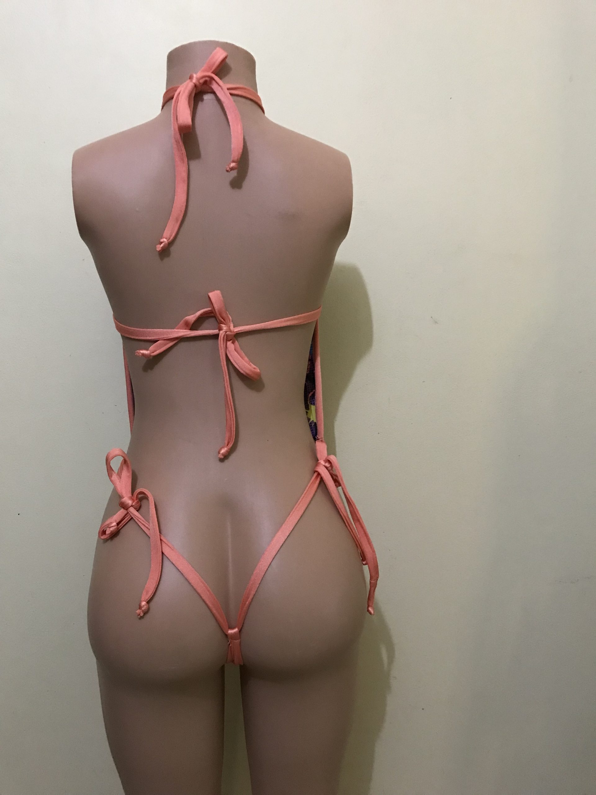 Multicolor star-print monokini with coral straps and thong cut, back view on mannequin